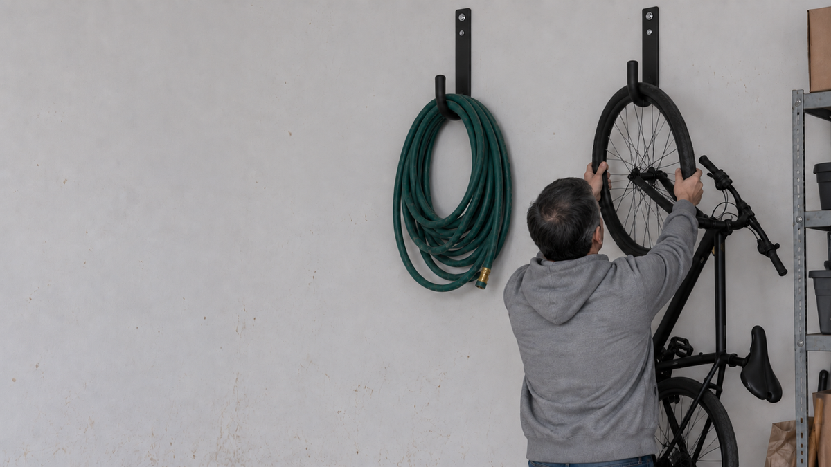 A garage wall with a bicycle hung on a wall hook